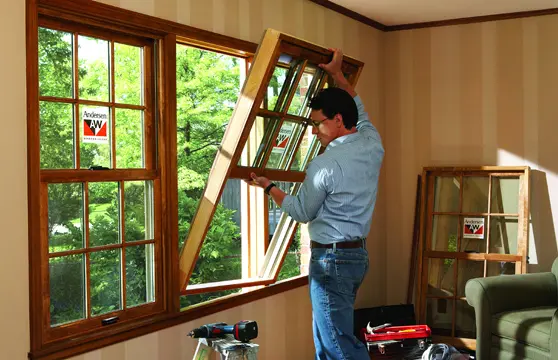 window-installation A man is working on the window of his house.