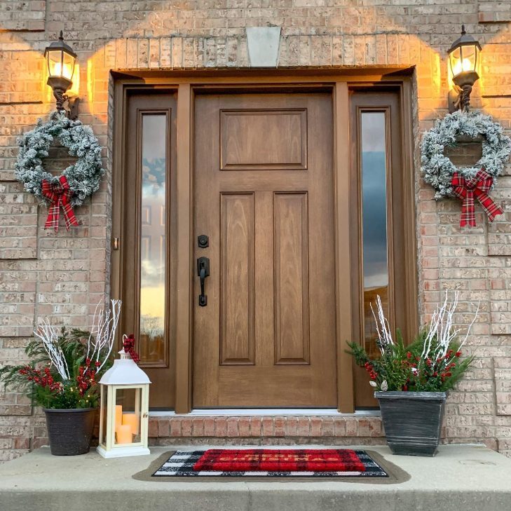 Screenshot_31-5-2025_122515_www.thermatru.com A front door with wreaths and candles on the wall.